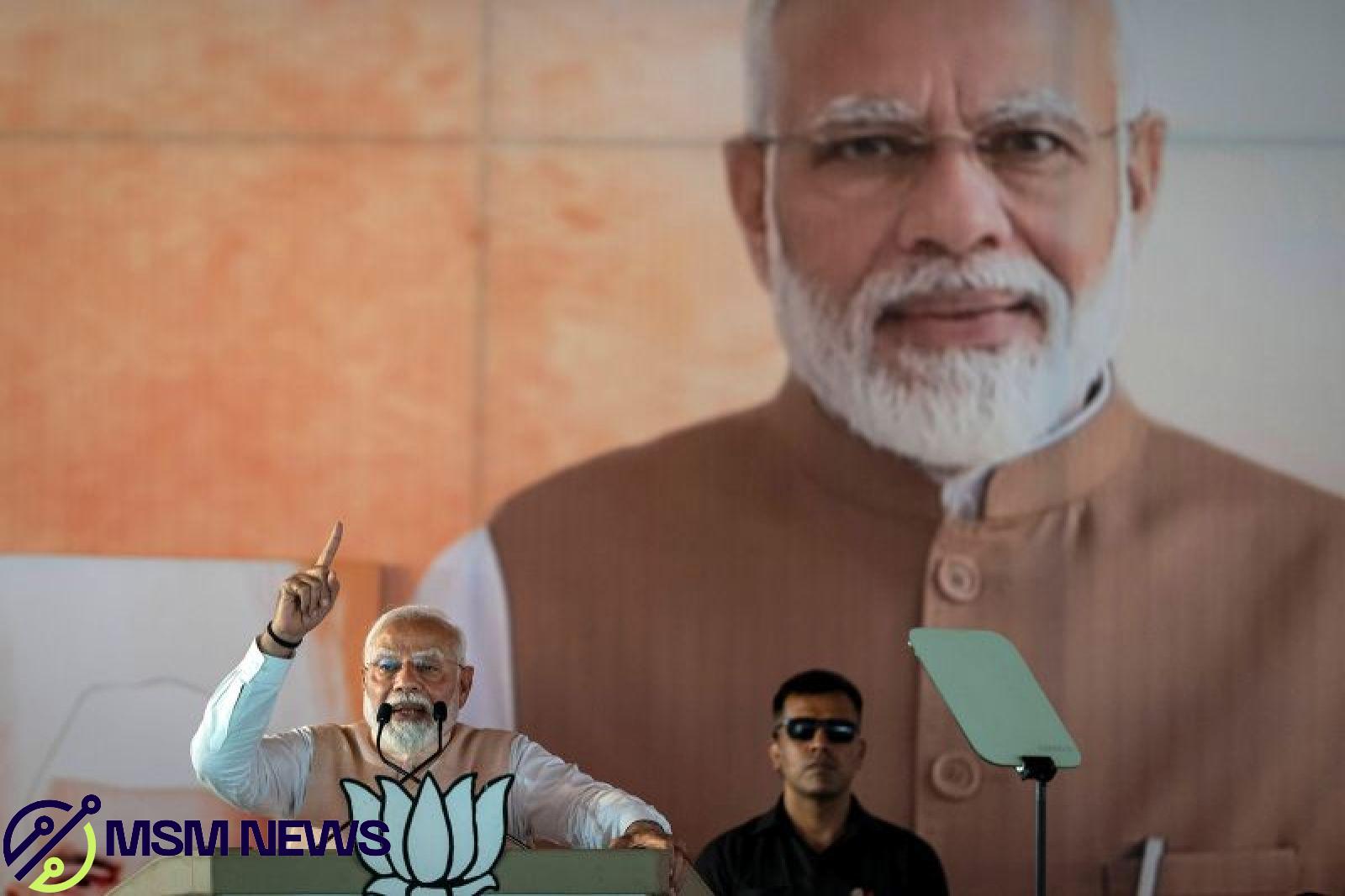 A large portrait of Indian Prime Minister Narendra Modi is displayed behind him as he speaks at an election campaign rally in Meerut, India, Sunday, March 31, 2024.